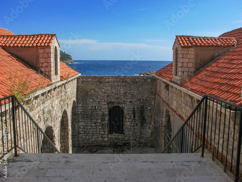 A part of Dubrovnik's city wall overlooking the Adriatic Sea on a sunny day with a clear blue sky. Image has copy space.