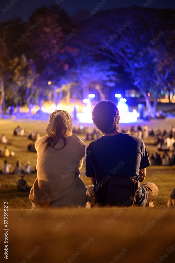 silhouette of young couple enjoying on outdoor romance concert at night