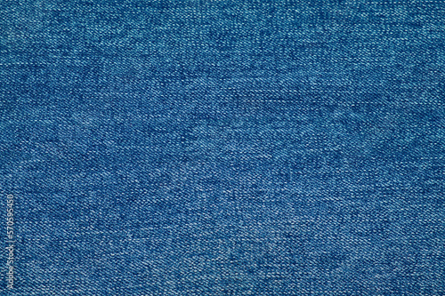 Close-up of blue jeans texture with. Denim textile background. Clothes fabric backdrop.