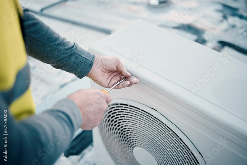Hands, air conditioner and maintenance with a man construction worker on a rooftop to install a cooling system. Engineer, hvac and ac repair with a male handyman servicing a building closeup