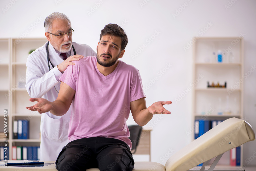 Obraz premium Young male patient visiting old male doctor