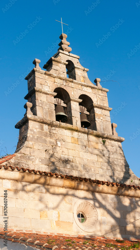 Sombra de ramas de arbol en fachada de iglesia de piedra en pueblo