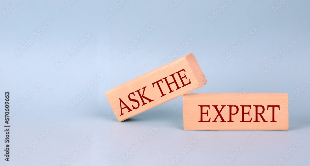 ASK THE EXPERT text on the wooden block, blue background ASK THE EXPERT text on the wooden block, blue background