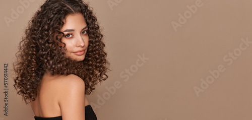Fashion studio portrait of beautiful smiling woman with afro curly hairstyle. Fashion and beauty