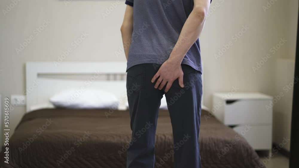 Hemorrhoidal pain, man suffering from hemorrhoids at home, health problems concept Hemorrhoidal pain, man suffering from hemorrhoids at home, health problems concept