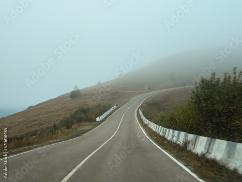 Foggy empty highway up through the pass. Road through a dense fog.
