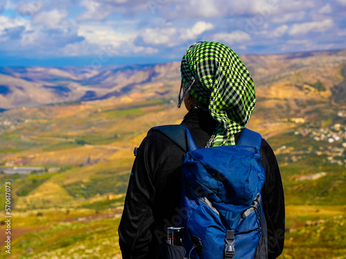 umm qais - irbid, jordan 06- Feb- 2023 - Hipster young girl with backpack enjoying sunset on peak of foggy mountain. Tourist traveler on background view mockup. Hiker looking sunlight in trip photo