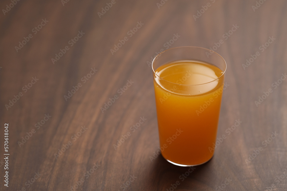 Fresh orange juice in thin glass on wooden table with copy space Fresh orange juice in thin glass on wooden table with copy space