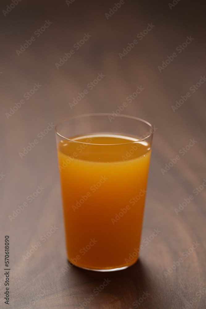 Fresh orange juice in thin glass on wooden table with copy space Fresh orange juice in thin glass on wooden table with copy space