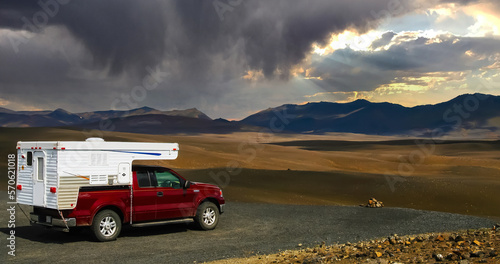 4x4 Camper van on view point plateau  endless lonely dry arid icelandic landscape  weather change with dark strom clouds - central Iceland