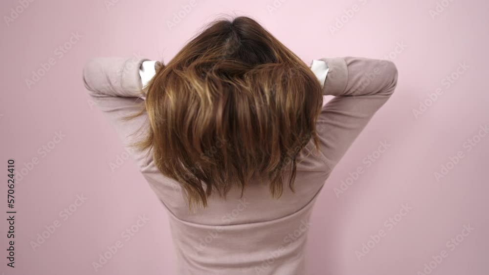 Young beautiful hispanic woman combing hair with hands over isolated pink background Young beautiful hispanic woman combing hair with hands over isolated pink background