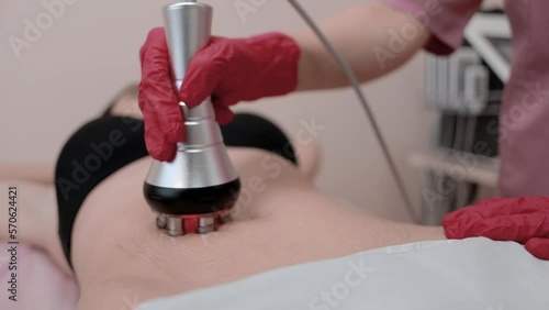 A girl beautician makes infra-red lifting procedures. Anti-cellulite massage program for health and weight loss. figure tone. Body care concept.