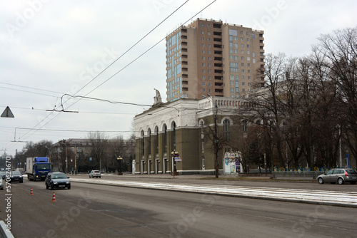 Winter photos of the big street Rabochaya in the city of Dnipro, ukraine. Wide road, parks, yards with cars, people, trees, Christmas trees, big houses and shops on a weekday.