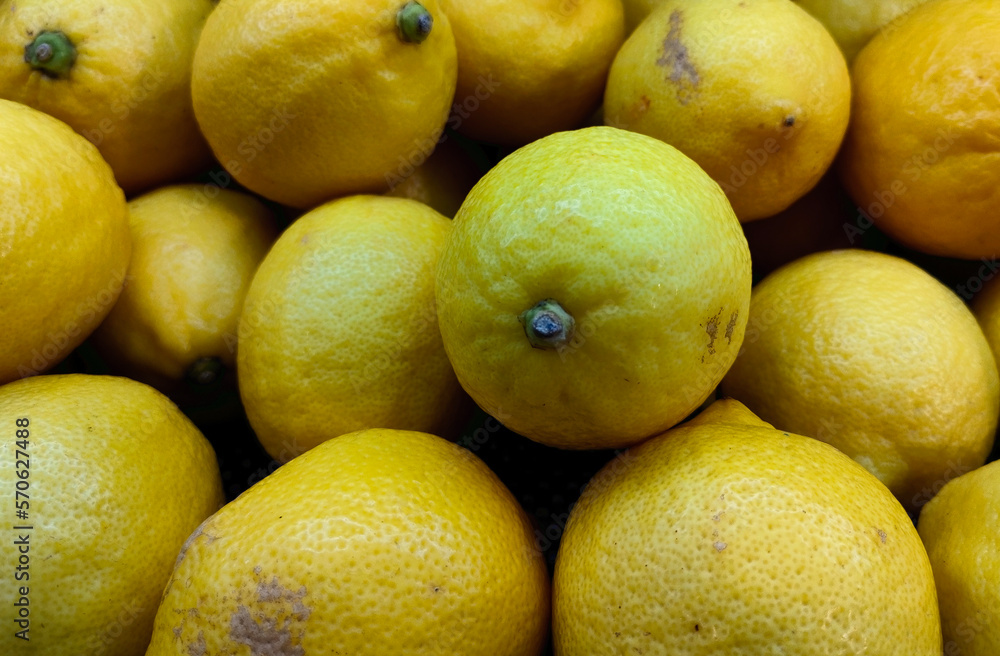 Close up pile of lemons in supermarket. Healthy vegetarian fruit photo isolated on landscape template. A bunch of sour fruits.