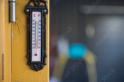 View of outdoor thermometer on yellow wooden pillar in winter day. Sweden.