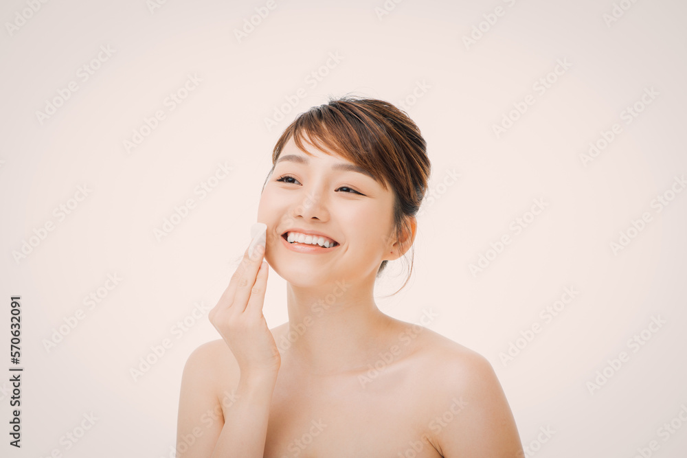 Beauty portrait of a happy half naked asian woman removing make-up with a cotton pad Beauty portrait of a happy half naked asian woman removing make-up with a cotton pad