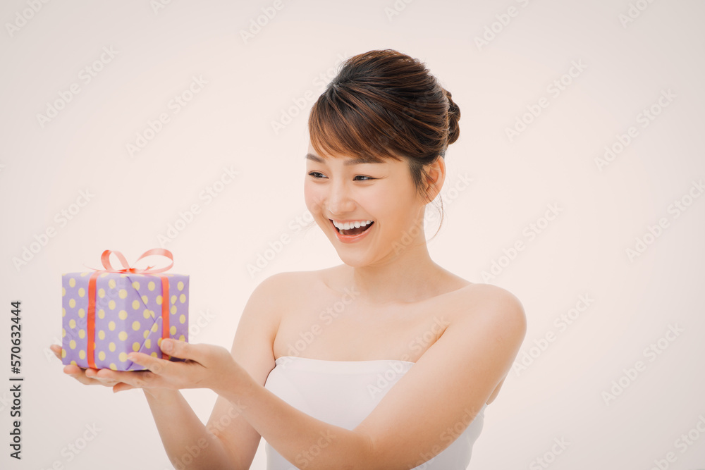 Happy young woman holding small gift box isolated on a white background Happy young woman holding small gift box isolated on a white background