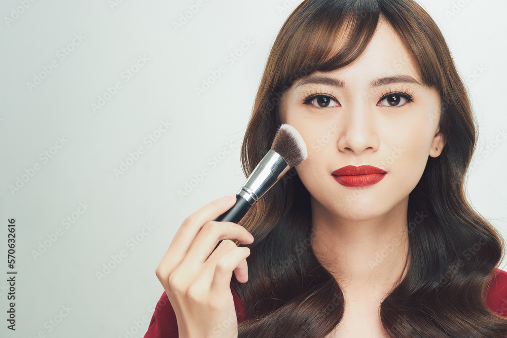 Beauty Asian Girl tan skin with Makeup Brushes. She smiling and looking to powder brush, Natural makeup Beauty Asian Girl tan skin with Makeup Brushes. She smiling and looking to powder brush, Natural makeup