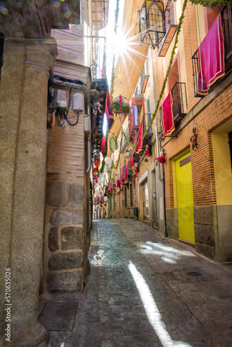 Narrow alleys of Toledo with shade cover  decorated balconies and sunbeams