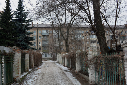 Quiet winter snowy streets, nooks and crannies of the street with houses, high fences in the city of Dnipro, ukraine.