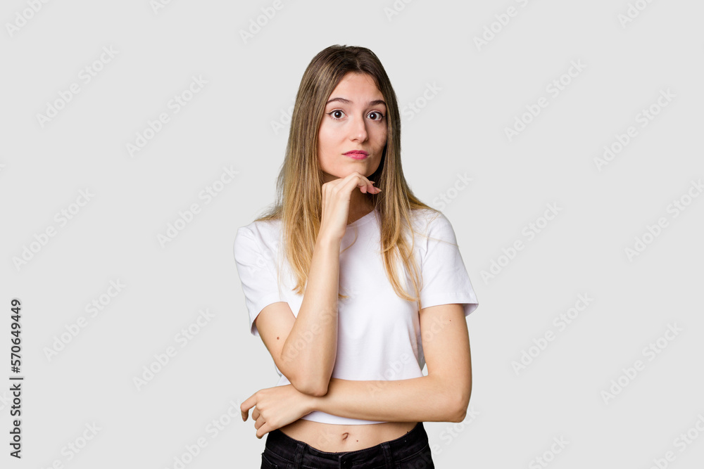 Young blonde posing for a portrait isolated, exuding natural beauty and radiance suspicious, uncertain, examining you. Young blonde posing for a portrait isolated, exuding natural beauty and radiance suspicious, uncertain, examining you.