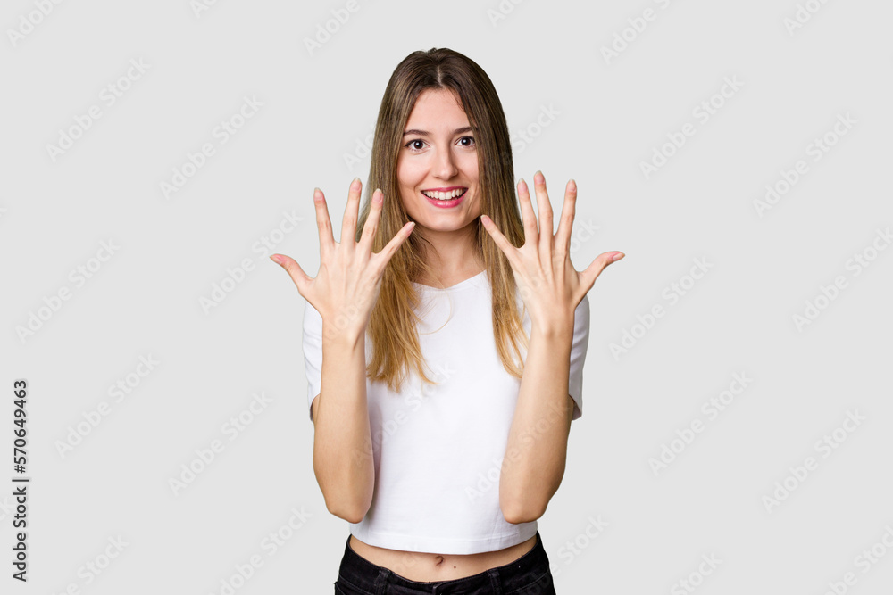 Young blonde posing for a portrait isolated, exuding natural beauty and radiance showing number ten with hands. Young blonde posing for a portrait isolated, exuding natural beauty and radiance showing number ten with hands.
