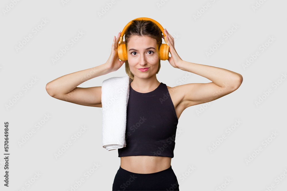 A young sportswoman enjoying music on her mobile phone, fueled with motivation