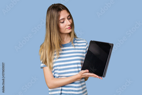 A beautiful young woman displays a sleek tablet, showcasing her tech-savvy and modern style.