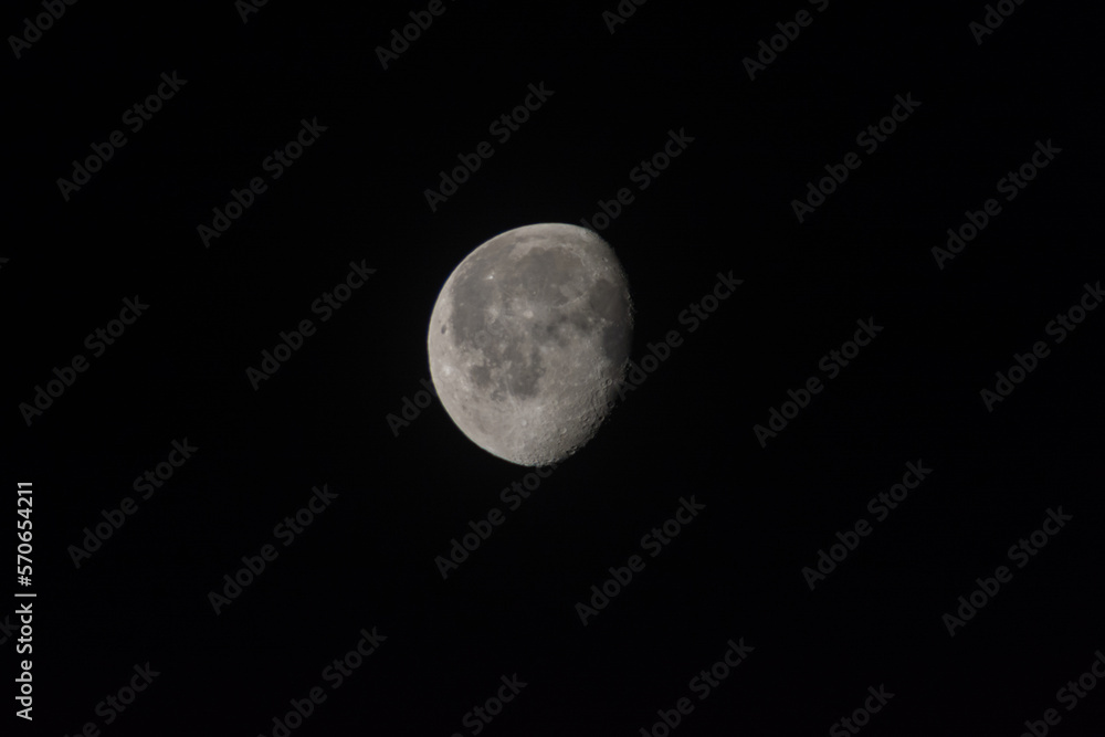 Half Moon detail with craters on black sky background Half Moon detail with craters on black sky background