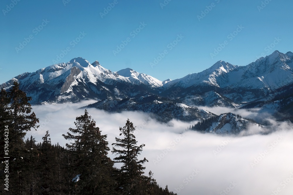 Panorama from rocky peak Gesia Szyja (Gooseneck) in Tatra Mountains in winter scenery. One of the best viewpoints of Slovak Tatras. Tatra National Park, Poland. Interesting phenomenon of inversion.