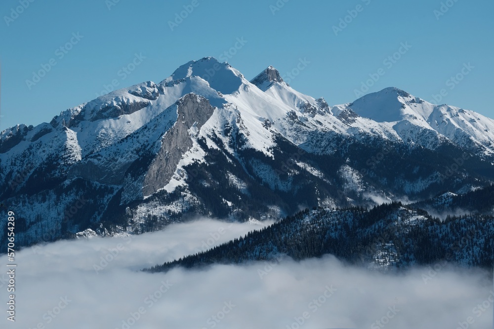 Fototapeta premium Panorama from rocky peak Gesia Szyja (Gooseneck) in Tatra Mountains in winter scenery. One of the best viewpoints of Slovak Tatras. Tatra National Park, Poland. Interesting phenomenon of inversion.