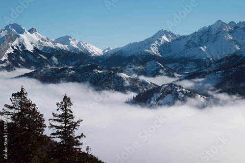 Panorama from rocky peak Gesia Szyja (Gooseneck) in Tatra Mountains in winter scenery. One of the best viewpoints of Slovak Tatras. Tatra National Park, Poland. Interesting phenomenon of inversion.