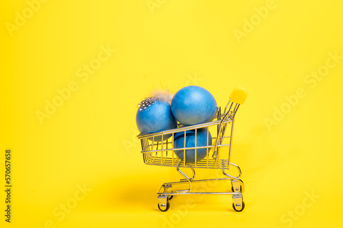 Supermarket trolley with blue easter eggs. Concept of buying