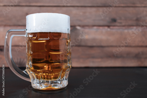 Light beer in a large glass on a wooden background