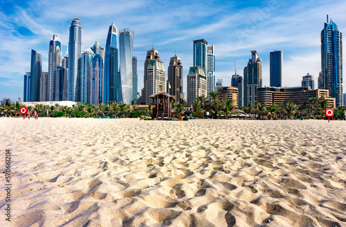 Dubai skyscraper skyline with palm trees and the sand of the beach