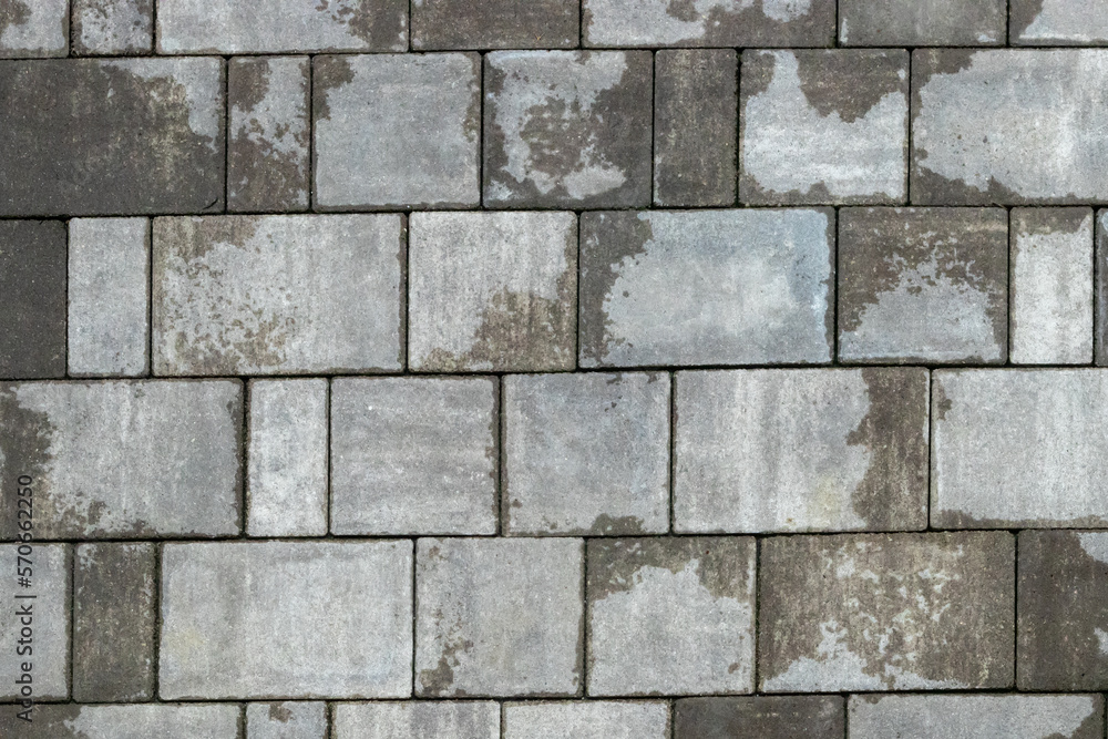 Naklejka premium Gray paving stones road. Paving surface road. Texture made of big gray cement bricks background