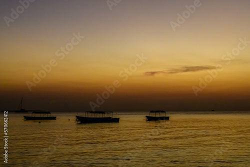 Traditional tourist boats at the Indian ocean when sunset. Zanzibar, Tanzania