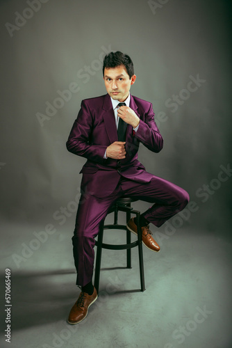 man in a suit sitting on a chair