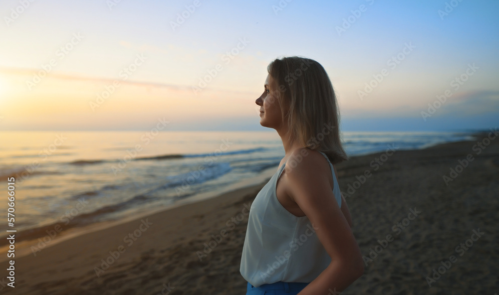 Woman stands on deserted beach and looks into the distance. Woman stands on deserted beach and looks into the distance.