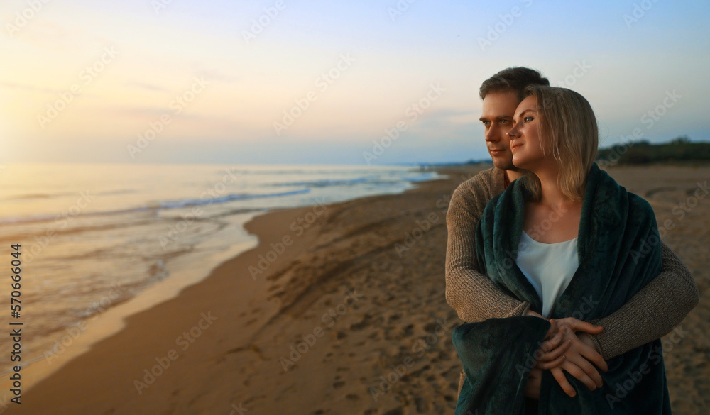 Attractive couple at sunset by the sea.