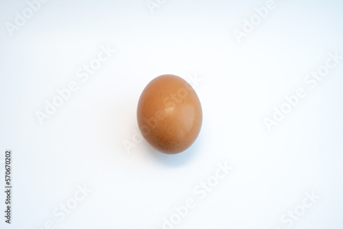 Single brown chicken egg isolated on white background. Food and cooking ingredient concept. 