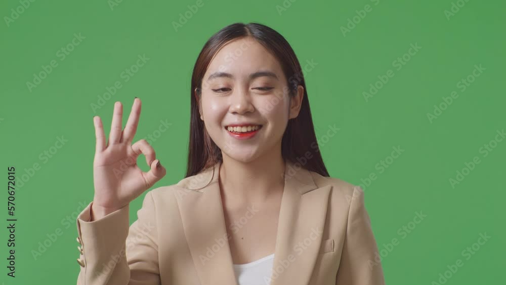 Close Up Of Asian Business Woman Showing Ok Gesture And Smiling While Standing In The Green Screen Studio
Close Up Of Asian Business Woman Showing Ok Gesture And Smiling While Standing In The Green Screen Studio
