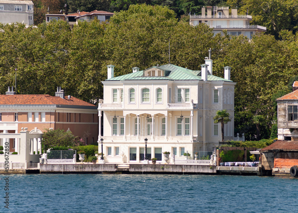 View from the sea of the European side of Bosphorus strait, Istanbul, Turkey, with traditional houses, and green mountains with dense green trees, in a summer day