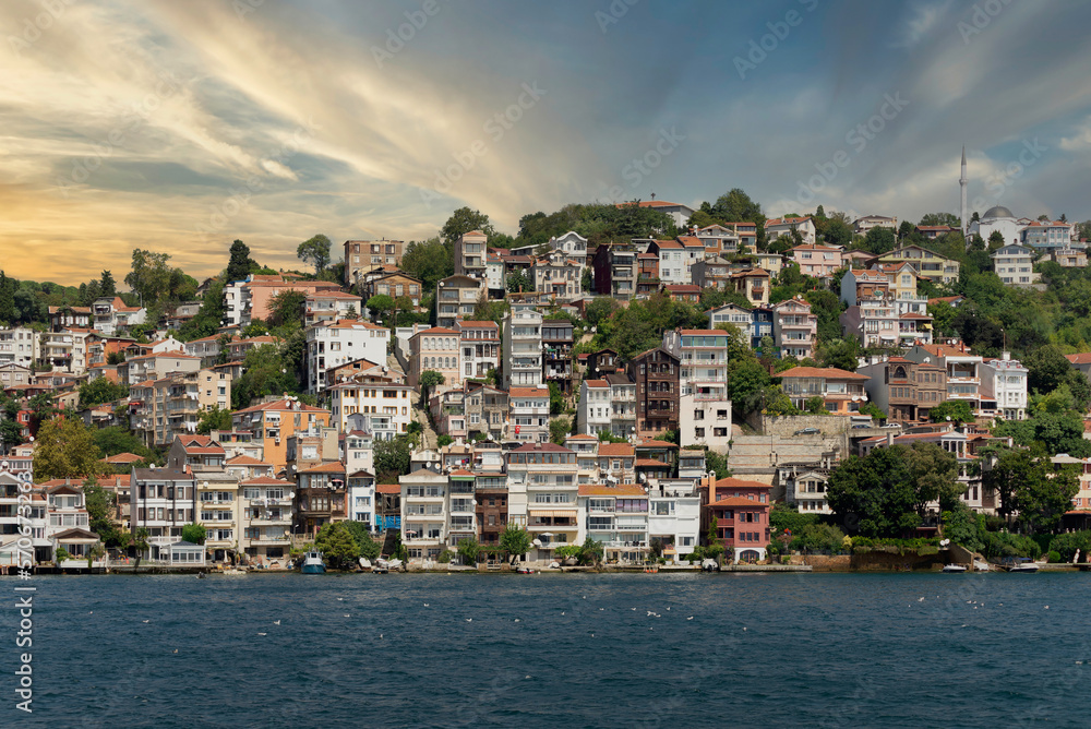 View from the sea of the green mountains of the Europian side of Bosphorus strait, with traditional houses and dense trees in a summer day before sunset, Istanbul, Turkey