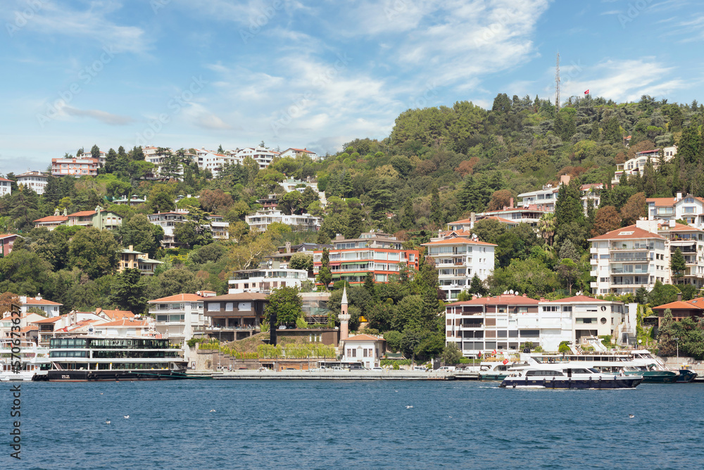 Bebek, View from the sea of the green mountains of the Europian side of Bosphorus strait, with docked boats, traditional houses and dense trees in a summer day, Istanbul, Turkey 