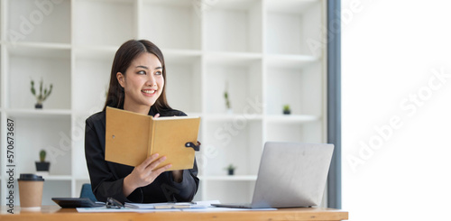 Asian businesswoman meeting at the office, taking notes and using a tablet at the office.