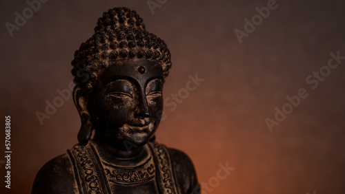 Wallpaper Mural Statue of Buddha close-up in a dark environment with golden background illuminated by candlelight. Empty space for text on the right Torontodigital.ca