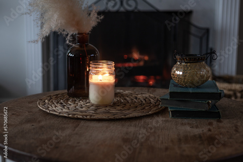 candle mock-up styled with pampas grass in front of fireplace background
