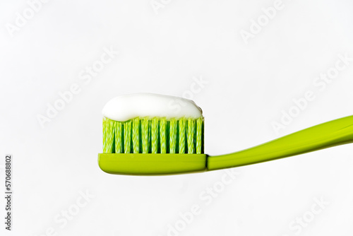Green toothbrush with toothpaste on a white background. Isolated.