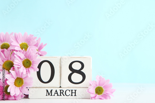 Flowers of chrysanthemums and wooden cube calendar on blue background